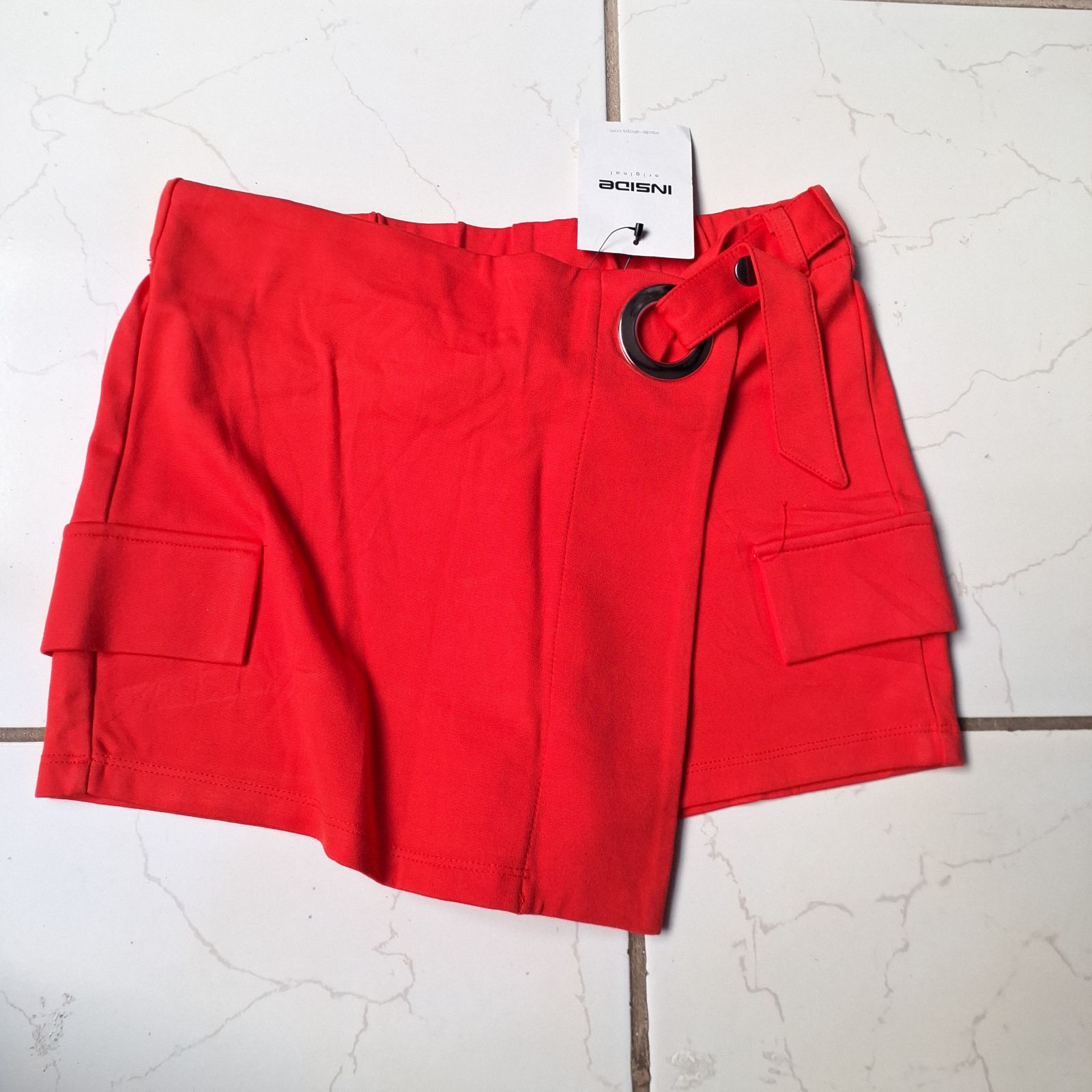 Falda corta roja con detalles de bolsillo