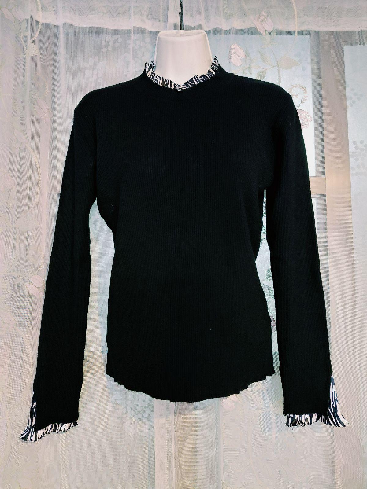 Suéter negro con cuello semi-alto y puños de gasa estampados