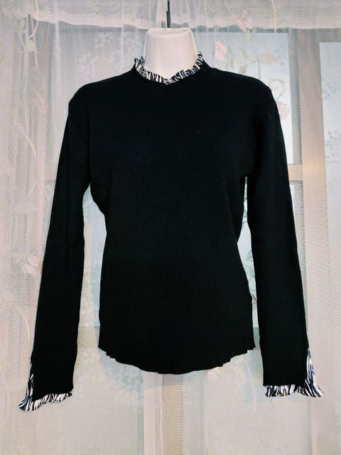 Suéter negro con cuello semi-alto y puños de gasa estampados