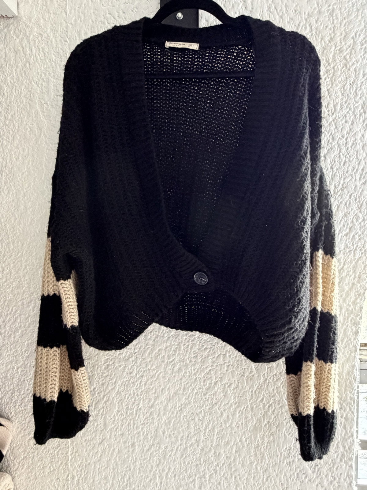 Suéter negro con rayas beige en mangas