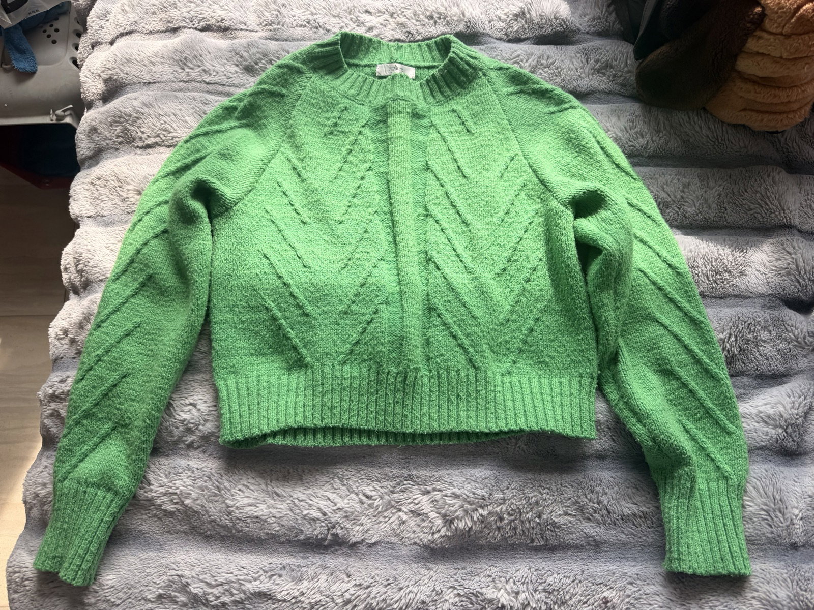 Suéter tejido verde con diseño de trenzas