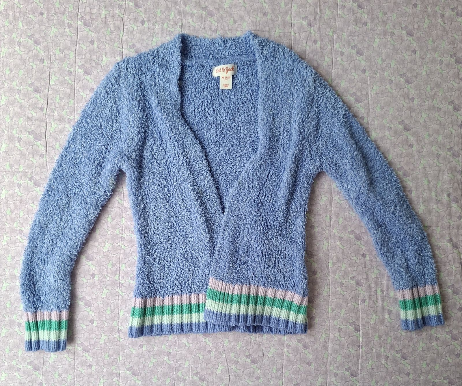Suéter de peluche azul con franjas de colores