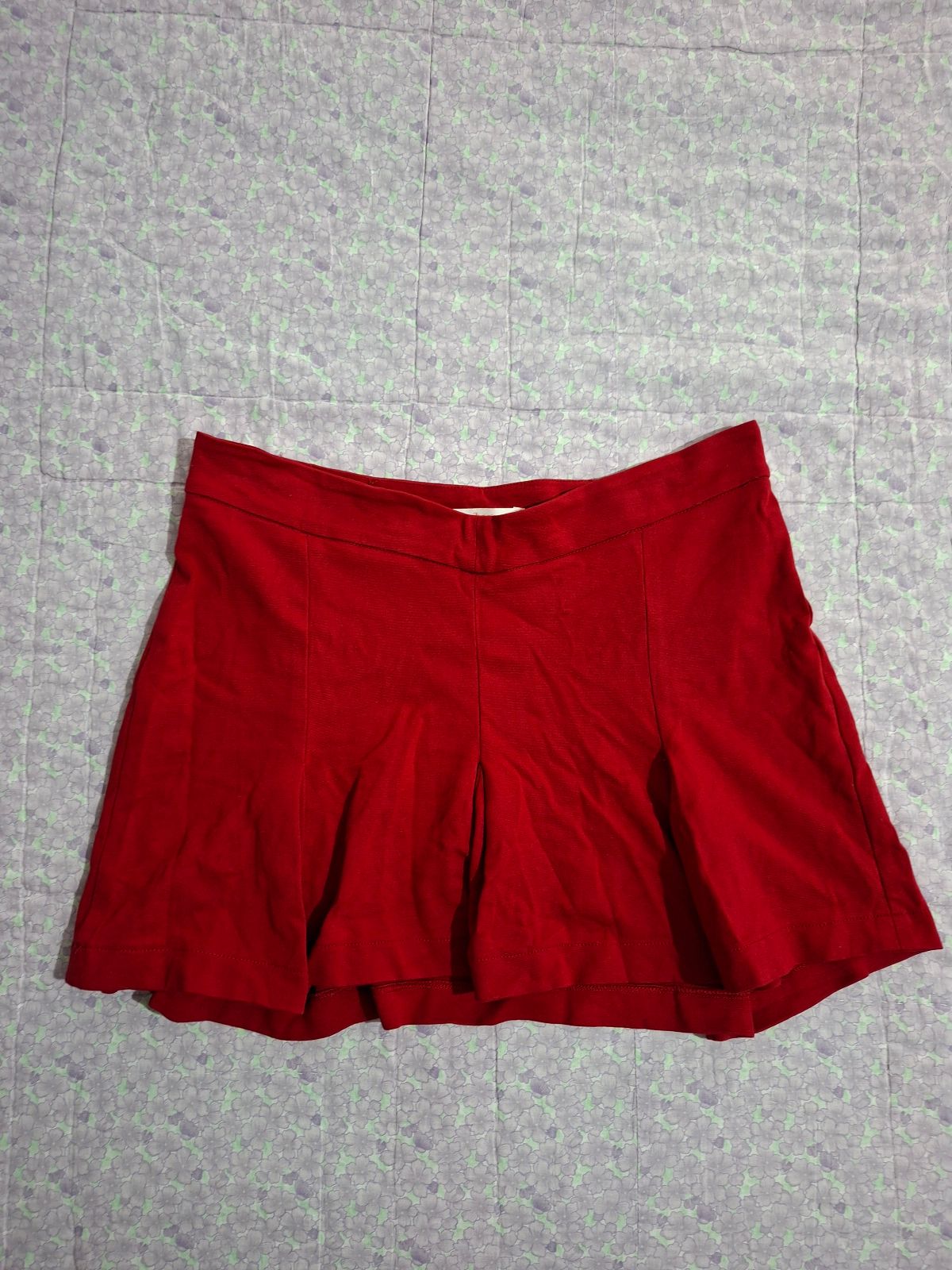Falda corta roja con detalles plisados